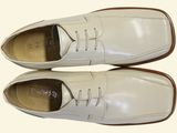 pair of white leather shoes with brown soles on a white surface