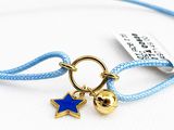 bracelet avec une breloque en forme d'étoile et une clochette, monté sur un cordon bleu