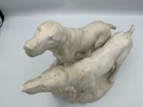 sculpture of two dogs sitting on top of each other on a white surface