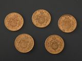 four different types of coins are shown on a black surface