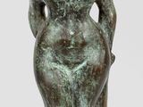 bronze statue of a woman sitting on a stool