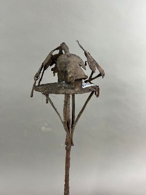 une sculpture représentant un oiseau perché au sommet d'un arbre