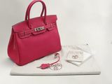 un sac à main rose et un sac blanc posés sur une table