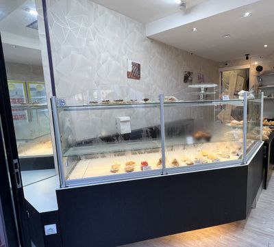 une photo d'une boulangerie avec une vitrine remplie de pâtisseries