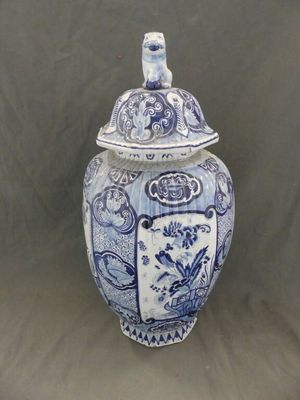 un vase bleu et blanc avec un couvercle posé sur une table