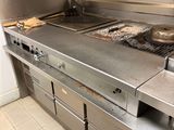 stainless steel counter top in a commercial kitchen with two burners and a griddle