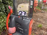 an orange and black forklift sitting in the middle of a yard