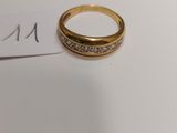 a gold ring with diamonds on it sitting on a piece of paper