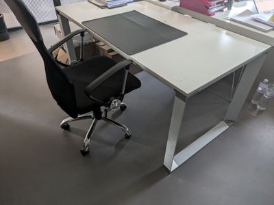 un bureau blanc avec une chaise noire devant