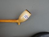 a wooden pipe with a sticker on it next to a pair of black shoes
