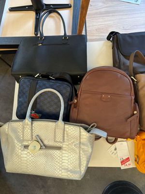 a lot of purses that are sitting on the floor