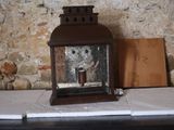 une bougie posée sur une table près d'un mur de briques