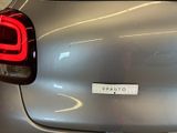 the rear end of a silver car with a sticker on it