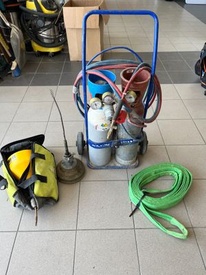 un petit chariot posé au sol, sur lequel se trouvent un tuyau et d'autres équipements