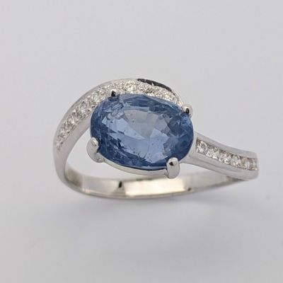 une bague ovale sertie d'un saphir bleu et de diamants, en or blanc 18 carats