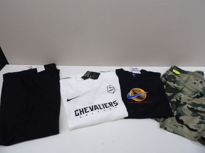 Plusieurs t-shirts et pantalons sont alignés sur une table