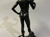 bronze statue of a woman holding a flower on a pedestal
