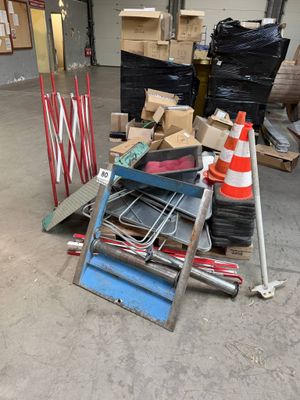 a pile of junk in a warehouse with a ladder and other items on the floor