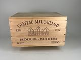 La caisse en bois, posée sur une table, contient une bouteille de vin.