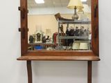 un miroir accroché au mur au-dessus d'une table sur laquelle est posée une lampe