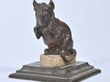 statue of a cat sitting on a pedestal on a white background