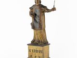a statue of a man holding a wand in his hand