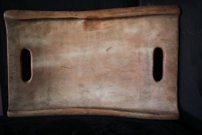 une planche à découper en bois percée de trous au milieu