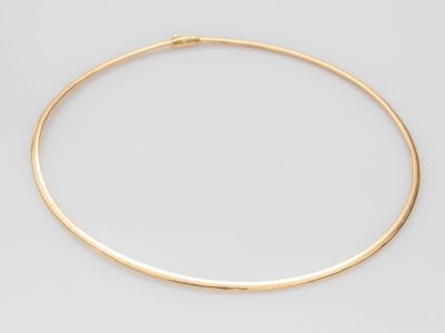un collier ras-du-cou en or sur fond blanc