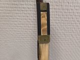 a close up of a pen with a wooden handle on a white surface