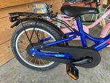 a blue bicycle parked in a garage next to a wooden wall