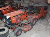 deux tondeuses à gazon et un tracteur dans un garage