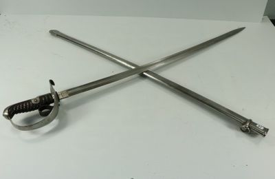 deux épées posées sur une table blanche, à côté d'une paire de ciseaux