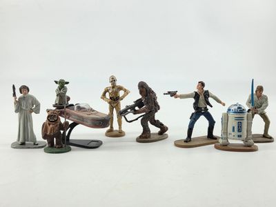 Des figurines « Star Wars » sont alignées sur une surface blanche