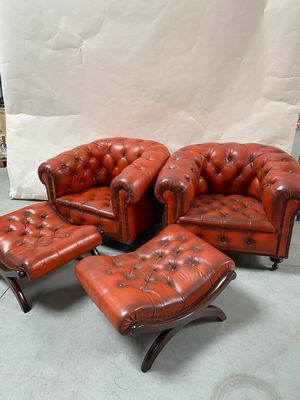 un fauteuil en cuir rouge et un repose-pieds dans une pièce