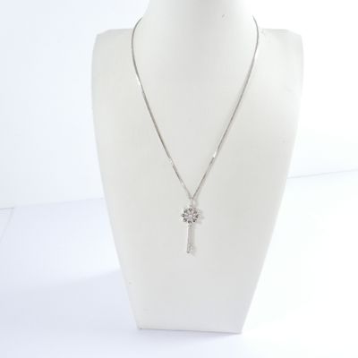 silver necklace with a cross pendant and a chain on a mannequin head