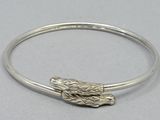 a close up of a silver bracelet with a dog head on it