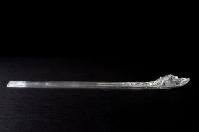 a glass spoon with ice on it sitting on a table