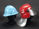 two helmets with helmets attached to them sitting on a black surface