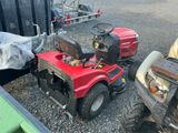 a small red tractor with a trailer and a trailer behind it