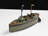 une petite maquette de bateau posée sur une surface blanche