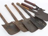 several old shovels are lined up in a row on a white surface