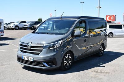 a grey van parked in a parking lot with other cars
