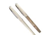 two pens sitting next to each other on a white surface