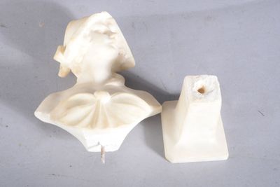 une statue représentant une femme et un bougeoir posés sur une table