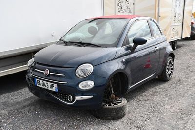 une petite voiture bleue garée à côté d'une remorque