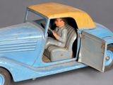 a blue toy car with a man sitting in the driver ' s seat