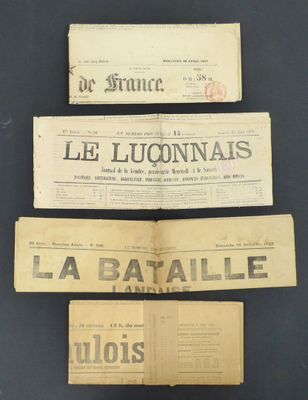 three old french newspapers are stacked on top of each other