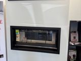 a fireplace in the middle of a room with a tv on the wall