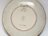 a white plate with a gold rim on a white table