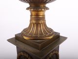 a gold vase on top of a pedestal on a white background